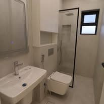 Guest bathroom with basin, mirror, and glazed shower enclosure