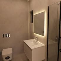Vanity unit with an illuminated mirror and concealed cistern