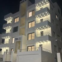 Night view of a Viola Housing elevation with the balconies picked out in light