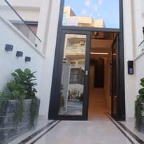 Main entrance of a Viola Housing building — glazed door, stone surround, and planting