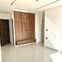 Entrance hall finished with a full-height walnut panelled wall and polished marble floor